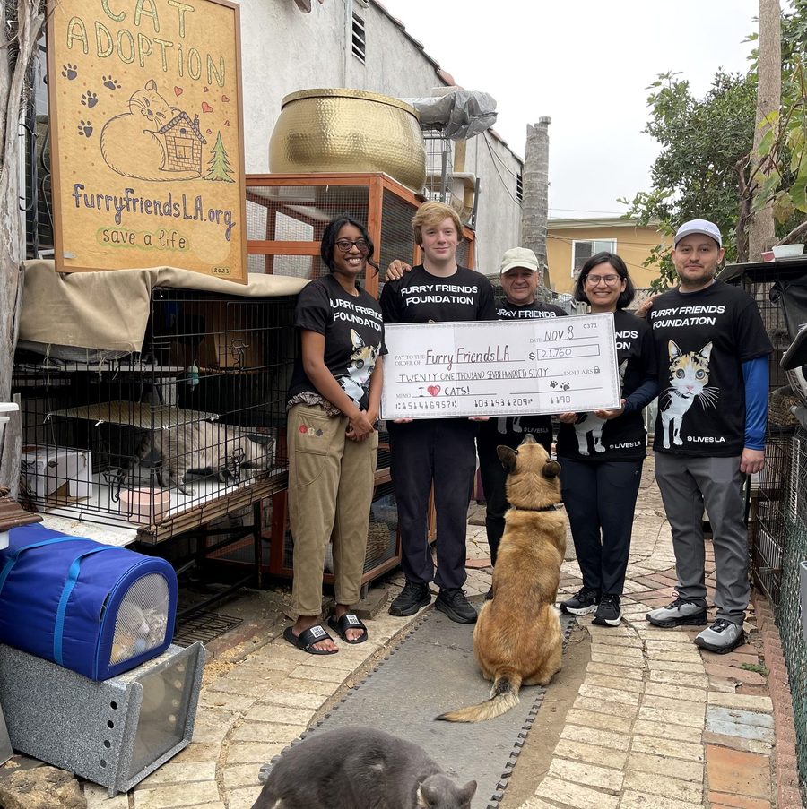 Cat rescue volunteers holding a donation check