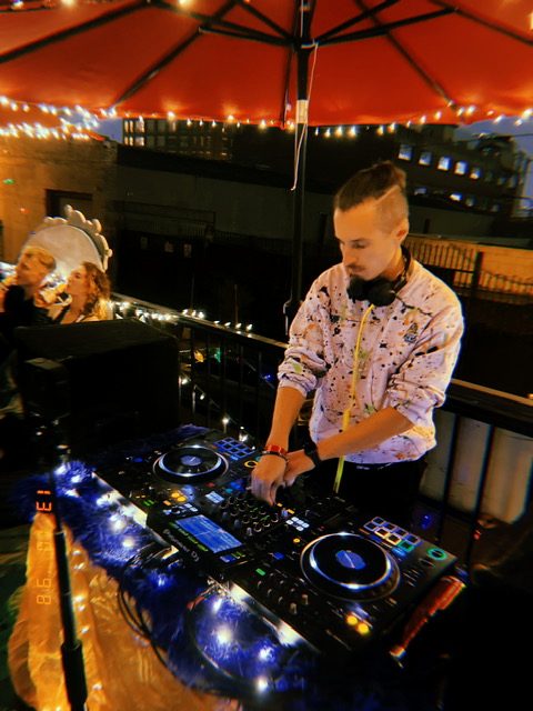 Arseny DJing on the Kitty Bus rooftop at night