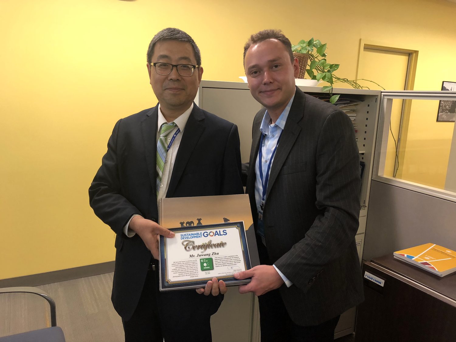 Arseny presenting a Sustainable Development Goals certificate to Mr. Juwang Zhu, a senior official at UN-DESA, at United Nations headquarters